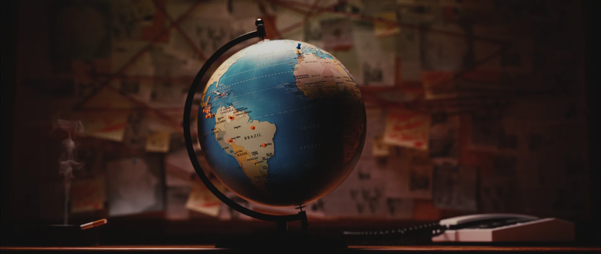 Globe on a desk against a wall of newspaper clippings